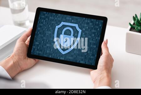 Woman using tablet, padlock icon on blue screen Stock Photo