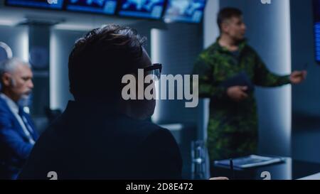 High-Ranking Military Man holds a Briefing to a Team of Government Agents and Politicians, Shows Satellite Surveillance Footage. Stock Photo