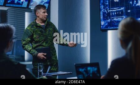 High-Ranking Military Man holds a Briefing to a Team of Government Agents and Politicians, Shows Satellite Surveillance Footage. Stock Photo