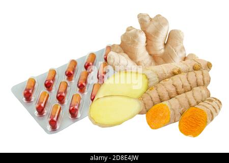 Curcuma and ginger roots capsules isolated against white background Stock Photo