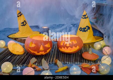 Two carved pumpkins with candles and spider web decoration for Halloween at dark or night time Stock Photo