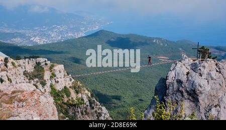 Yalta, Russia - September 20, 2020: Beautiful mountain landscape of the southern Crimea Ai Petri plateau A male walking along a suspension bridge betw Stock Photo