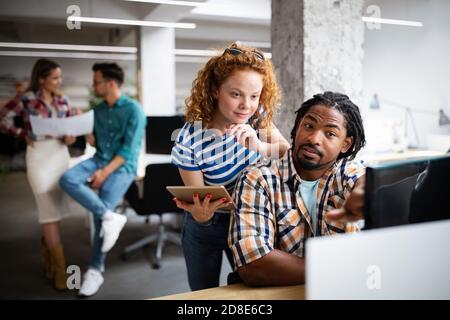 Programmers cooperating at IT company developing apps Stock Photo