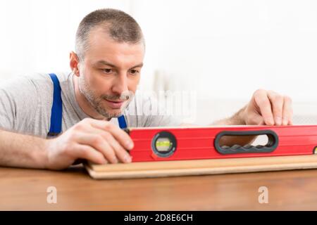 Carpenter Working Using Level Tool Making Wooden Cabinet Indoor Stock Photo