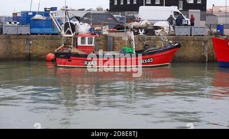 28 October 2020 - Whitstable, UK: Red fishing boat alongside in harbour Stock Photo