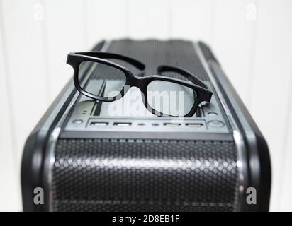 Black eyeglasses is on top of PC tower case with usb connection sockets, power and reset buttons, close up view Stock Photo