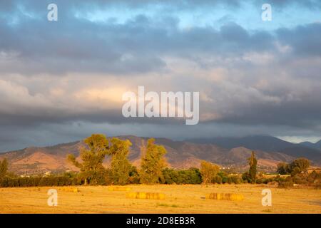 View over a field towards mountains at sunset, Argaka, Paphos District, Cyprus Stock Photo