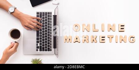 Top view of female SMM manager using laptop at workplace and drinking coffee, collage with words ONLINE MARKETING Stock Photo