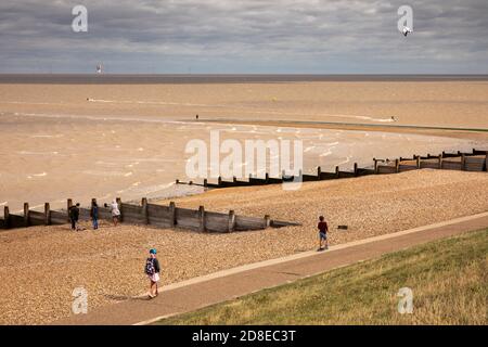 UK, Kent, Whitstable, Tankerton beach, walkers on promenade below Marine Parade Stock Photo