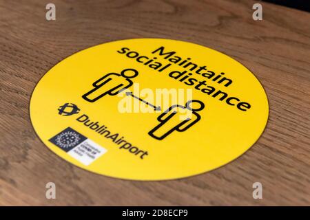 Maintain social distancing yellow sign due to Covid 19 pandemic in coffee shop or cafe at the Dublin Airport Ireland Europe Stock Photo