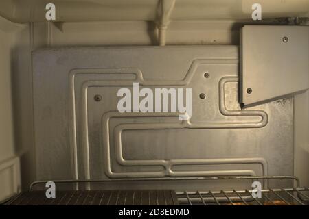 Open vintage refrigerator showing the interior with interior light and shelf Stock Photo