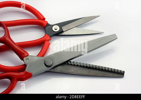Tailoring scissors zigzag on a white background. Serrated fabric scissors. Tools for cutting heavy or lightweight fabrics, edging or cutting decorativ Stock Photo