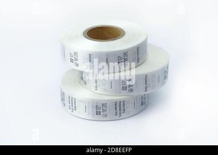 clothing care labels. Clothing labels, sewing accessories. White skeins, a roll of ribbon with information on washing and fabric composition. Stock Photo