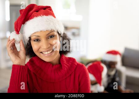 Portrait of woman in Santa hat smiling at home Stock Photo