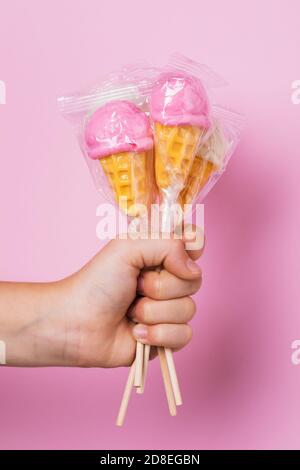 Five different lollipops in a childs hand on a pink background Stock Photo