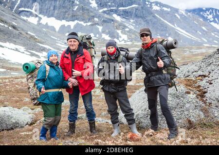 Group of climbers showing thumbs up, portrait from senior couple, teenage boy and adult man, people dressing mountaineering outfit Stock Photo