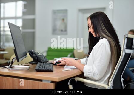 Young woman manager working at her workplace in the office, Caucasian white ethnicity Stock Photo