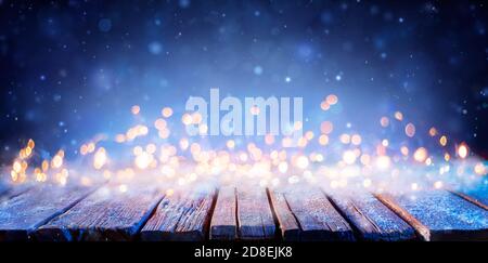 Snowy Wooden Table With Defocused Lights - Abstract Christmas Background Stock Photo