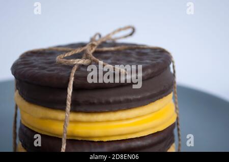 Stack of round cookies  covered dark and yellow chocolate, assorted Stock Photo