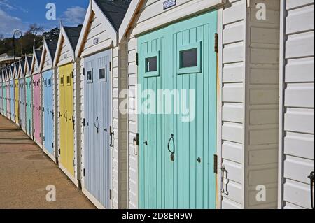 Lyme Regis, Dorset and soft pastel coloured wooden doors adorn beach huts on the seafront promenade. Stock Photo