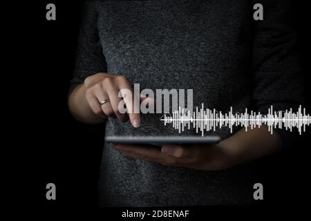 Hand clicks on the tablet to listen to music, listening to music on mobile devices, the concept of music with you, software used for recording, editin Stock Photo