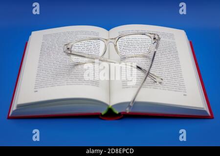 reading glasses on an open book Stock Photo