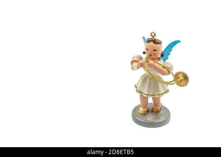 Closeup of a original handcarved wooden German Christmas Angel figurine on a white background, playing a trumpet Stock Photo