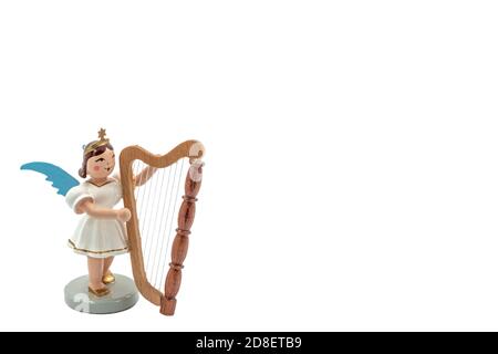 Closeup of a original handcarved wooden German Christmas Angel figurine playing a harp on a white background Stock Photo
