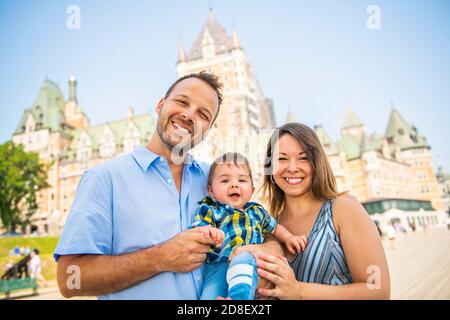 Family of three with baby outside in summer season Stock Photo