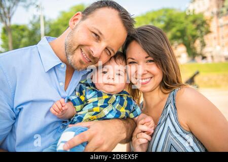 Family of three with baby outside in summer season Stock Photo