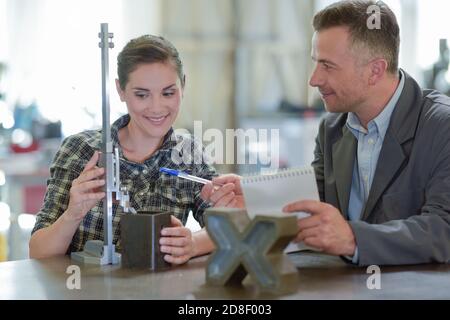 engineer and female apprentice working on machine in factory Stock Photo