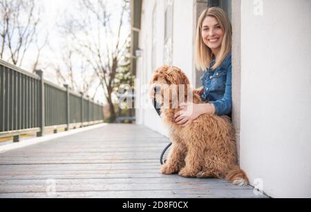 Labradoodle Dog and woman outside on balcony Stock Photo