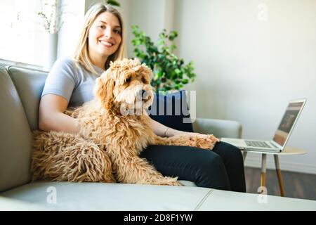 woman with his Golden Labradoodle dog at home Stock Photo
