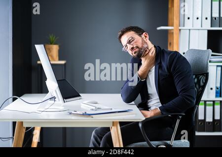 Young Man With Tense Neck Pain. Office Posture Problem Stock Photo