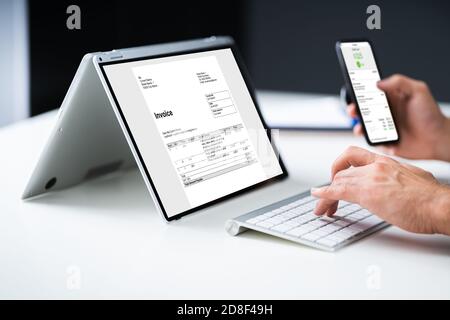 Digital Invoice Document On Tablet Or Laptop. Accountant Tech Stock Photo