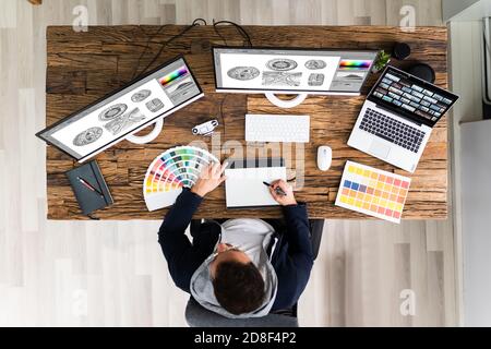 Designer Editing Photos On Multiple Computer Screens Stock Photo