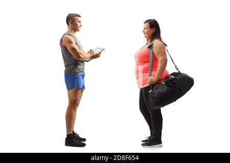 Full length profile shot of a fitness instructor giving an advice to an overweight woman isolated on white background Stock Photo