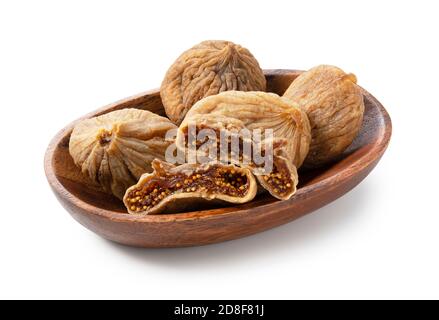 Dried figs and dried figs cut in half in a wooden plate on a white background. Stock Photo
