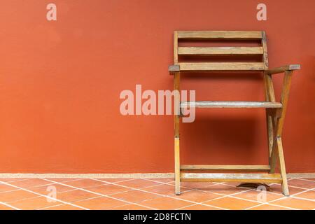 Wooden chairs on terracotta floors and orange plaster walls background, wooden chairs on the balcony. Stock Photo