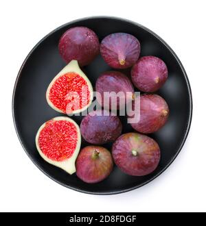 Fresh figs. Whole and sliced figs on a black plate   isolated on white background, top view Stock Photo