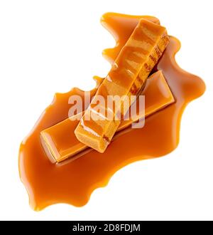 Caramel candies and caramel sauce isolated on a white background.  Golden Butterscotch toffees close  up Stock Photo