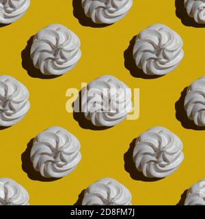 Seamless marshmallow or meringue pattern isolated on yellow background. Sweets and food themes. Suitable for wallpaper, textile, background, poster, b Stock Photo
