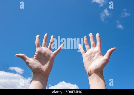 Close-up of female hands, empty open palms on a background of blue sky. Number ten in sign language. Copy space Stock Photo