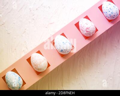 easter, holidays and tradition concept - row of colored artificial eggs on pink. Stock Photo