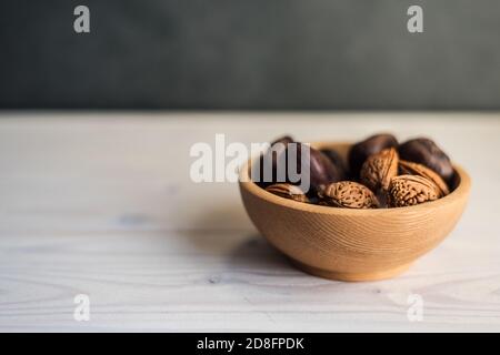 Closeup shot of walnuts and chestnuts on a bowl in a table Stock Photo