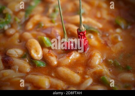 Tasty Chilly Spicy Cooked Beans With two Red Peppers Still Boiling Stock Photo