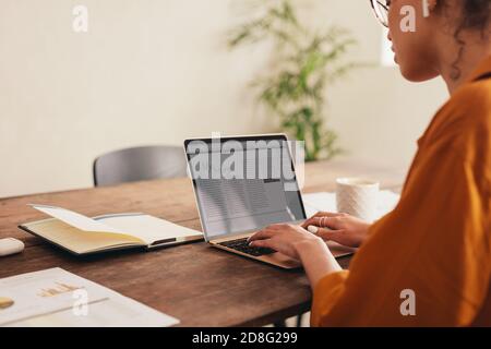 Female blogger working on the laptop. Woman at home writing a blog on her laptop in her living room. Stock Photo