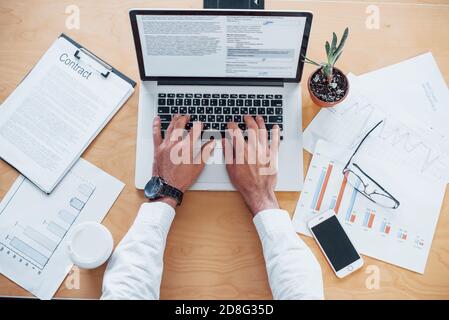 Top view of senior businessman's hands that working by laptop Stock Photo
