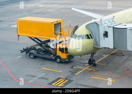 Yellow truck near to a passenger plane, pre-flight service airport Stock Photo