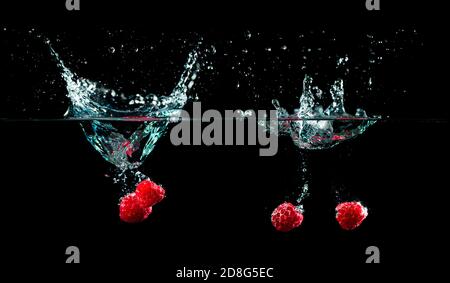 raspberries splash in to water on black background Stock Photo